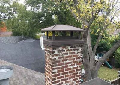 Red brick chimney with black cover
