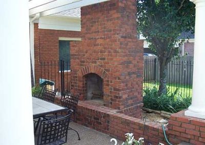 red brick outdoor fireplace with white columns on each side