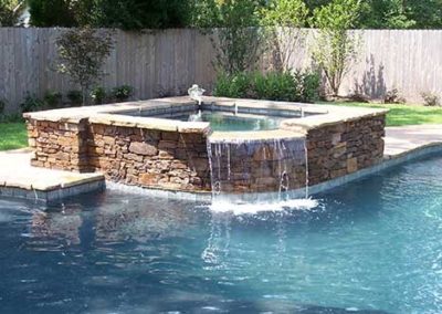 Custom Built Hot Tub & Pool Edging with wood fence in background