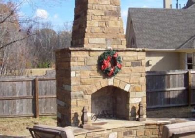 Festive stone outdoor fireplace with Christmas wreath