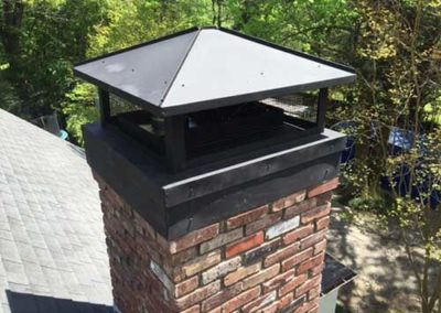 Red brick chimney with black cap