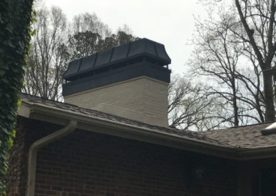 white brick chimney with black chimney cap