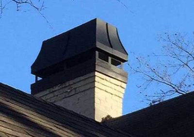 White brick chimney with black flue cover