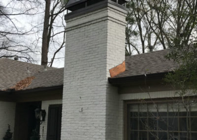 White brick chimney with black chimney cap