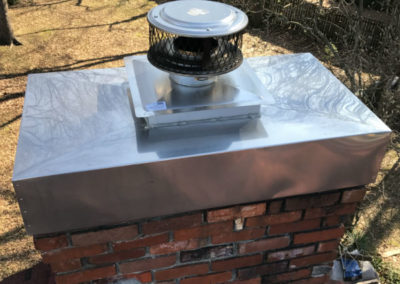 Red brick chimney with steel chase cover