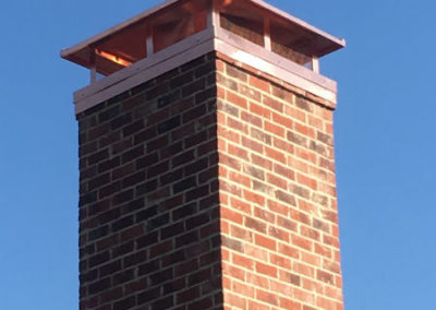 Red brick chimney with copper chimney crown